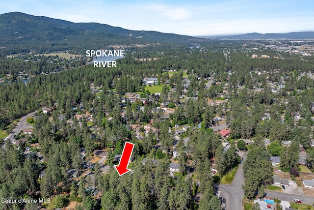 221 S Ridgewood Dr, Post Falls, ID 83854 - aerial overview of property's location featuring a mountainous background and a forest