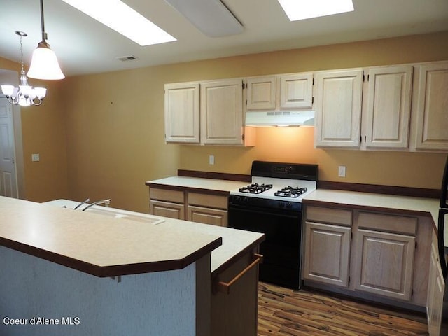 3696 N Steven Pl, Coeur Dalene, ID 83815 - kitchen with gas range oven, under cabinet range hood, a sink, dark wood-style floors, and a breakfast bar