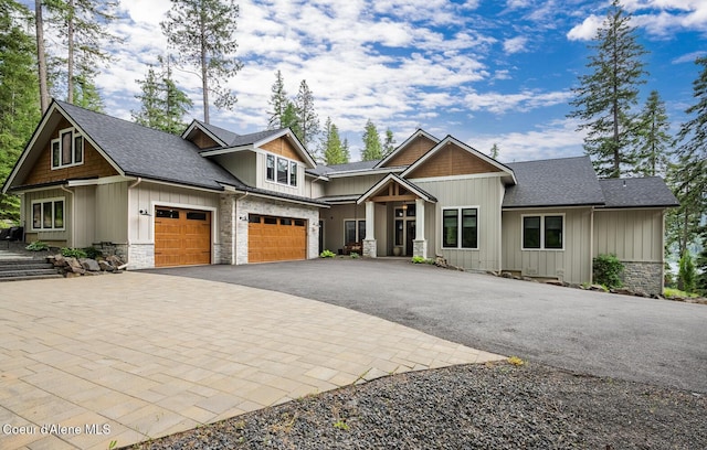 6767 S Renaissance Way, Coeur Dalene, ID 83814 - craftsman-style house with stone siding, asphalt driveway, board and batten siding, roof with shingles, and an attached garage