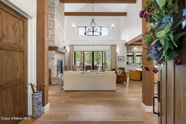 6767 S Renaissance Way, Coeur Dalene, ID 83814 - living room featuring light wood finished floors, high vaulted ceiling, beam ceiling, a chandelier, and a large fireplace