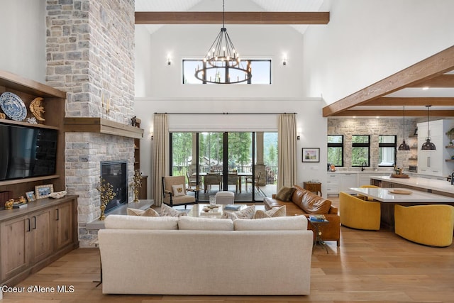 6767 S Renaissance Way, Coeur Dalene, ID 83814 - living area featuring beam ceiling, high vaulted ceiling, light wood-type flooring, a fireplace, and a chandelier
