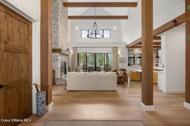 6767 S Renaissance Way, Coeur Dalene, ID 83814 - living room with light wood-type flooring, beamed ceiling, high vaulted ceiling, a chandelier, and a fireplace