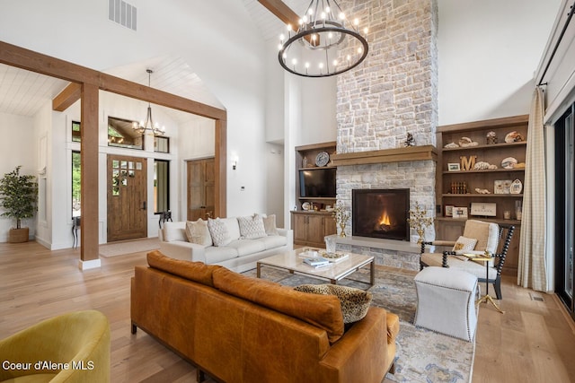 6767 S Renaissance Way, Coeur Dalene, ID 83814 - living area featuring a chandelier, high vaulted ceiling, light wood-style floors, beam ceiling, and a stone fireplace