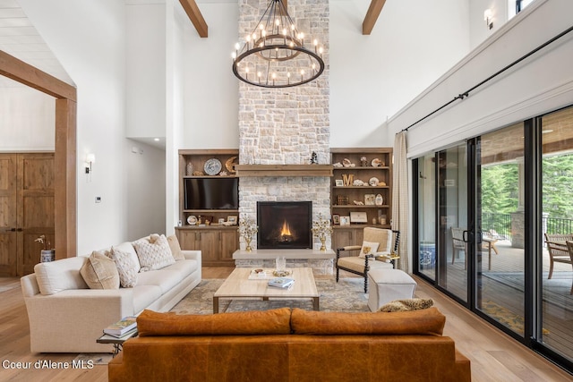 6767 S Renaissance Way, Coeur Dalene, ID 83814 - living room with a high ceiling, wood finished floors, a chandelier, beam ceiling, and a stone fireplace