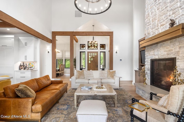 6767 S Renaissance Way, Coeur Dalene, ID 83814 - living area with a chandelier, a high ceiling, wood finished floors, and a fireplace