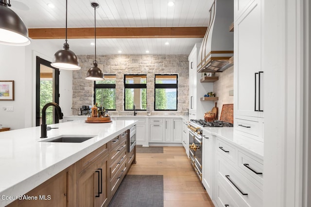 6767 S Renaissance Way, Coeur Dalene, ID 83814 - kitchen with stainless steel appliances, wall chimney exhaust hood, light wood-type flooring, a wood ceiling with exposed beams, and recessed lighting