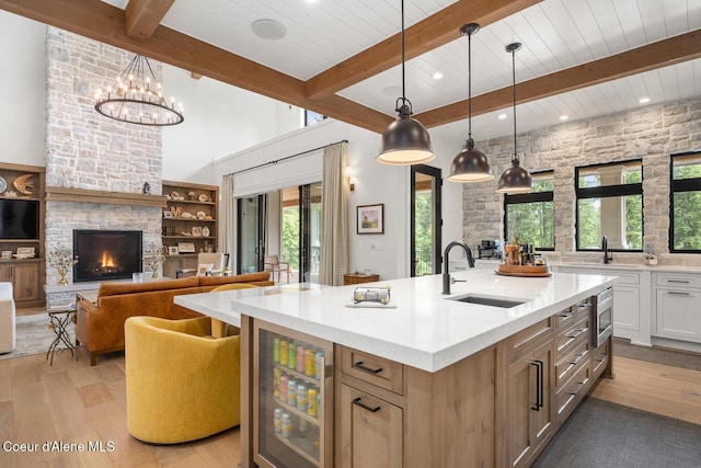 6767 S Renaissance Way, Coeur Dalene, ID 83814 - kitchen featuring wine cooler, light wood-style flooring, light countertops, a center island with sink, and recessed lighting