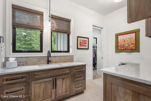 6767 S Renaissance Way, Coeur Dalene, ID 83814 - bathroom with vanity, backsplash, a walk in closet, and tile patterned floors