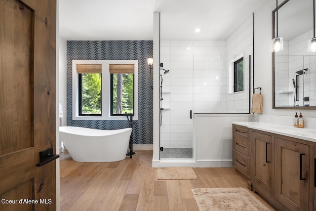 6767 S Renaissance Way, Coeur Dalene, ID 83814 - bathroom featuring a shower stall, vanity, wood finished floors, and a soaking tub