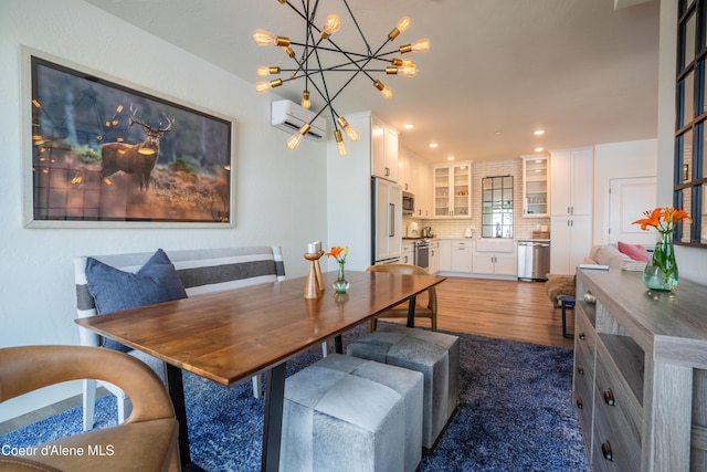 115 E Lake St Unit 203, Sandpoint, ID 83864 - dining room featuring wood finished floors, an AC wall unit, recessed lighting, and a chandelier
