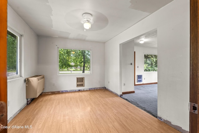 206 E 2nd Ave, Clark Fork, ID 83811 - unfurnished room featuring a ceiling fan, wood finished floors, heating unit, and baseboards