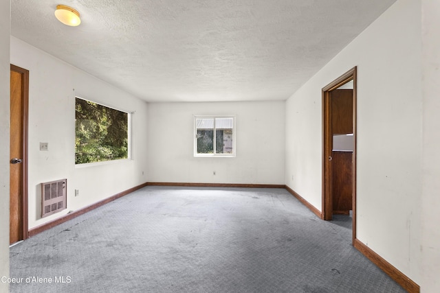 206 E 2nd Ave, Clark Fork, ID 83811 - carpeted spare room featuring heating unit, baseboards, and a textured ceiling