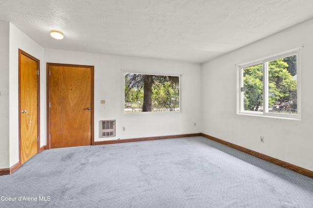 206 E 2nd Ave, Clark Fork, ID 83811 - carpeted spare room featuring heating unit, baseboards, and a textured ceiling