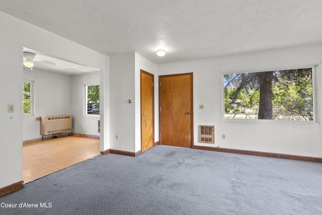 206 E 2nd Ave, Clark Fork, ID 83811 - carpeted empty room with heating unit, baseboards, a ceiling fan, and a textured ceiling