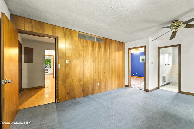 206 E 2nd Ave, Clark Fork, ID 83811 - spare room featuring ceiling fan, wood walls, carpet floors, and baseboards