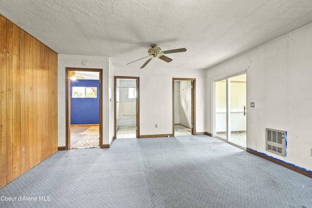 206 E 2nd Ave, Clark Fork, ID 83811 - unfurnished bedroom with carpet floors, ensuite bath, wood walls, heating unit, and baseboards