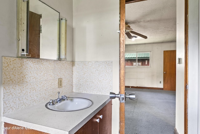 206 E 2nd Ave, Clark Fork, ID 83811 - bathroom featuring ceiling fan, vanity, backsplash, baseboards, and a textured ceiling