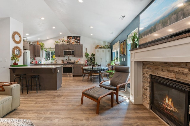 84 E Cabinet Wagon Rd, Clark Fork, ID 83811 - living area featuring vaulted ceiling, a fireplace, light wood-style flooring, and recessed lighting