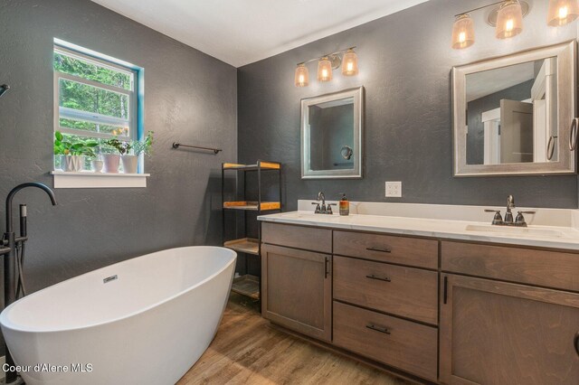 84 E Cabinet Wagon Rd, Clark Fork, ID 83811 - full bathroom featuring a textured wall, wood finished floors, double vanity, and a freestanding tub