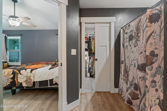 84 E Cabinet Wagon Rd, Clark Fork, ID 83811 - full bathroom featuring wood finished floors, a textured wall, curtained shower, and a ceiling fan