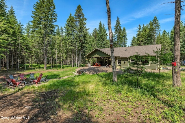 84 E Cabinet Wagon Rd, Clark Fork, ID 83811 - view of yard featuring a fire pit, a patio, and a forest view