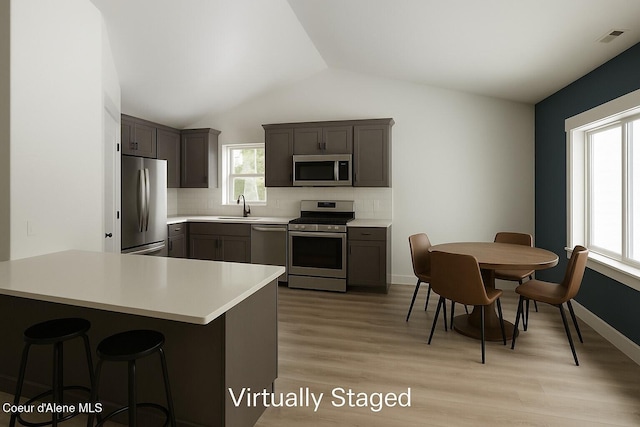 84 E Cabinet Wagon Rd, Clark Fork, ID 83811 - kitchen with stainless steel appliances, light countertops, backsplash, lofted ceiling, and light wood-type flooring