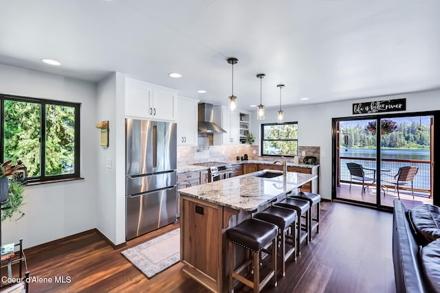 115 W Lakeview Blvd, Priest River, ID 83856 - kitchen with stainless steel appliances, wall chimney range hood, dark wood-type flooring, light stone countertops, and recessed lighting