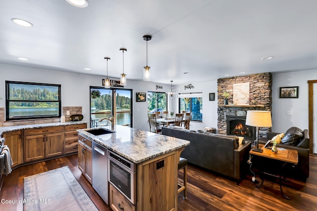 115 W Lakeview Blvd, Priest River, ID 83856 - kitchen with brown cabinets, dark wood finished floors, light stone countertops, stainless steel dishwasher, and recessed lighting