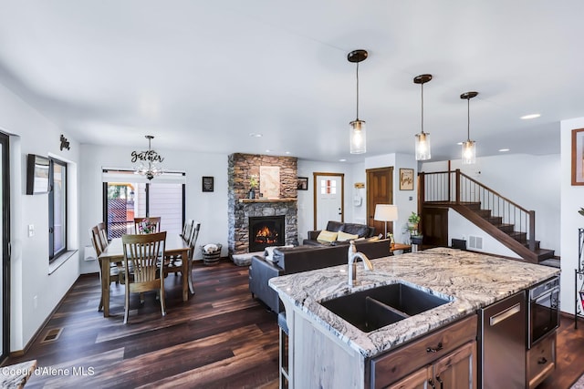 115 W Lakeview Blvd, Priest River, ID 83856 - kitchen with dark wood-style floors, a fireplace, a chandelier, hanging light fixtures, and recessed lighting