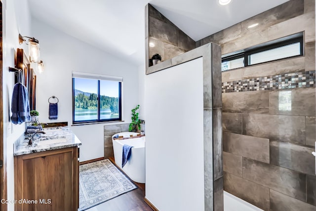 115 W Lakeview Blvd, Priest River, ID 83856 - full bathroom with vaulted ceiling, a freestanding tub, double vanity, walk in shower, and wood finished floors