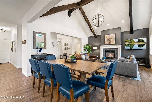 3889 E Avery Ln, Coeur Dalene, ID 83814 - dining room featuring a chandelier, beamed ceiling, a brick fireplace, light wood-style flooring, and high vaulted ceiling