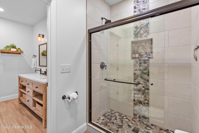3889 E Avery Ln, Coeur Dalene, ID 83814 - bathroom featuring wood finished floors, a shower stall, and vanity