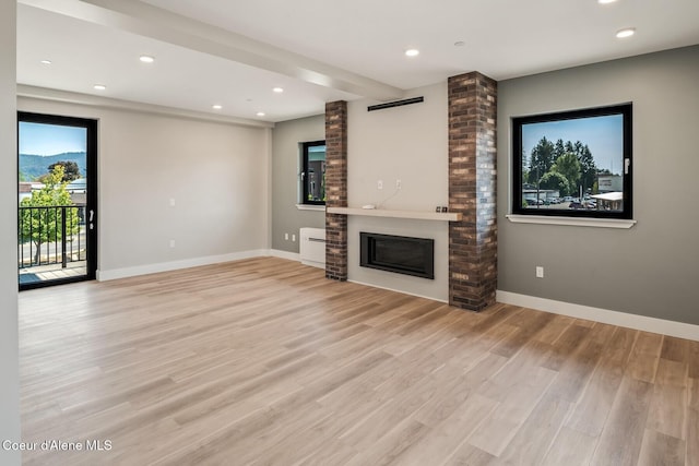 503 Cedar St # 203, Sandpoint, ID 83864 - unfurnished living room featuring a fireplace, light wood-style floors, and recessed lighting