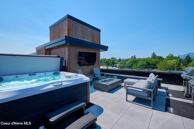 503 Cedar St # 203, Sandpoint, ID 83864 - view of patio featuring a hot tub and an outdoor living space with a fire pit