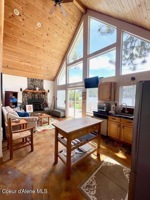 5734 W Freeman Rd, Rathdrum, ID 83858 - living room featuring high vaulted ceiling, a wooden ceiling with exposed beams, a fireplace, and a ceiling fan