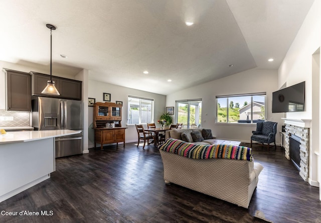 22830 E Bailey Ct, Liberty Lake, WA 99019 - living area with recessed lighting, lofted ceiling, dark wood-style flooring, a stone fireplace, and a textured ceiling