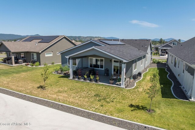 22830 E Bailey Ct, Liberty Lake, WA 99019 - view of front facade with a patio, roof mounted solar panels, roof with shingles, and a front lawn