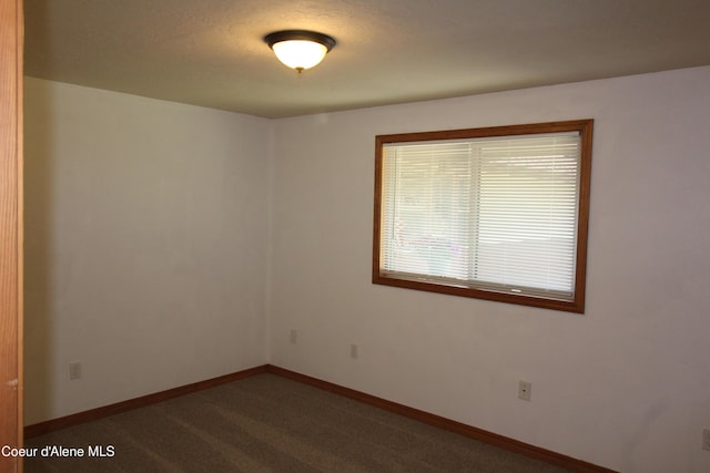 807809 E Timber Ln, Coeur Dalene, ID 83814 - spare room with baseboards and dark colored carpet