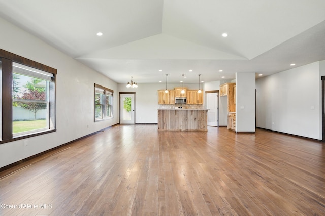 6984 W Blacktail Ave, Rathdrum, ID 83858 - unfurnished living room with lofted ceiling, a chandelier, wood finished floors, and recessed lighting