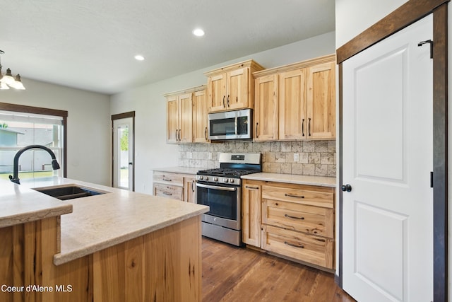 6984 W Blacktail Ave, Rathdrum, ID 83858 - kitchen with appliances with stainless steel finishes, light brown cabinets, decorative backsplash, dark wood finished floors, and recessed lighting
