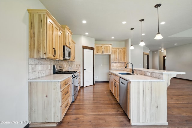 6984 W Blacktail Ave, Rathdrum, ID 83858 - kitchen featuring stainless steel appliances, light brown cabinetry, dark wood finished floors, tasteful backsplash, and light countertops