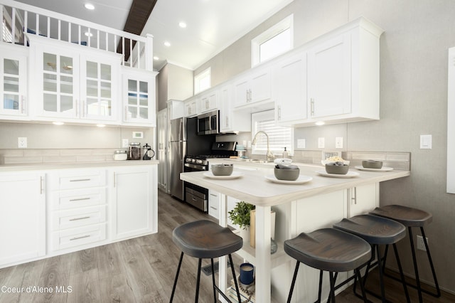 716 Raeder St, Kooskia, ID 83539 - kitchen featuring appliances with stainless steel finishes, a kitchen breakfast bar, white cabinets, light countertops, and recessed lighting