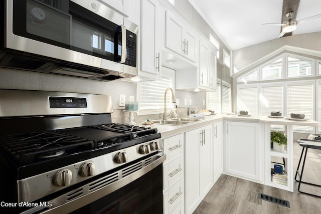 716 Raeder St, Kooskia, ID 83539 - kitchen featuring appliances with stainless steel finishes, a sink, a ceiling fan, white cabinetry, and light wood-style floors