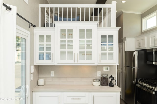 716 Raeder St, Kooskia, ID 83539 - kitchen with stainless steel appliances, decorative backsplash, white cabinets, light countertops, and crown molding