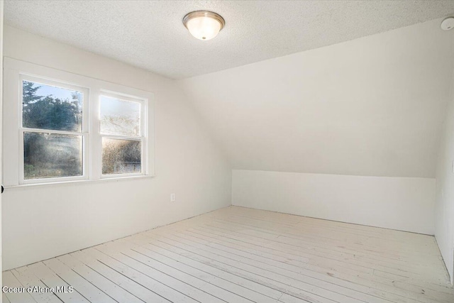 928 N 7th St, Coeur Dalene, ID 83814 - bonus room featuring vaulted ceiling, hardwood / wood-style floors, and a textured ceiling