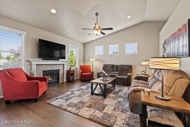 3265 E Galway Cir, Post Falls, ID 83854 - living room with a ceiling fan, lofted ceiling, a textured ceiling, dark wood-style floors, and a glass covered fireplace