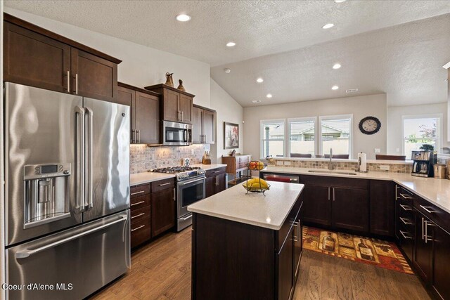 3265 E Galway Cir, Post Falls, ID 83854 - kitchen with high quality appliances, a textured ceiling, light countertops, dark wood-style floors, and lofted ceiling