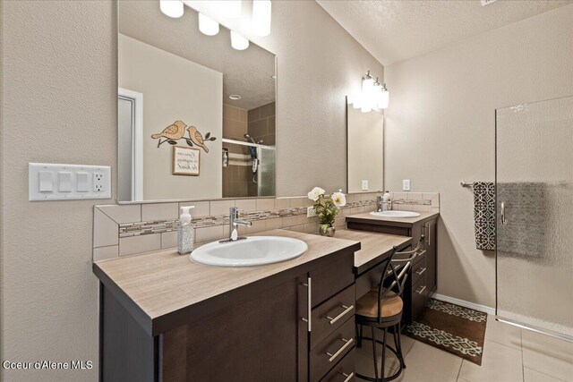 3265 E Galway Cir, Post Falls, ID 83854 - full bathroom featuring double vanity, a shower stall, tile patterned floors, a textured ceiling, and decorative backsplash