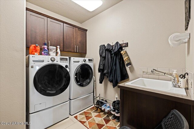 3265 E Galway Cir, Post Falls, ID 83854 - laundry area featuring cabinet space, washing machine and dryer, and light tile patterned floors