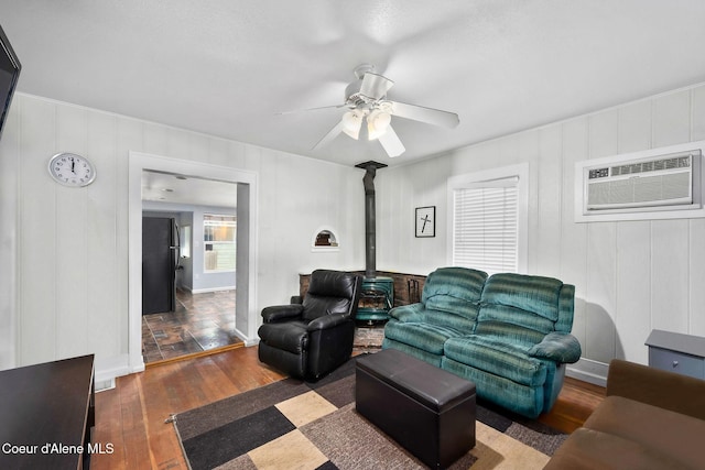1901 E Pennsylvania Ave, Coeur Dalene, ID 83814 - living area featuring a wood stove, hardwood / wood-style flooring, a ceiling fan, a wall unit AC, and a decorative wall